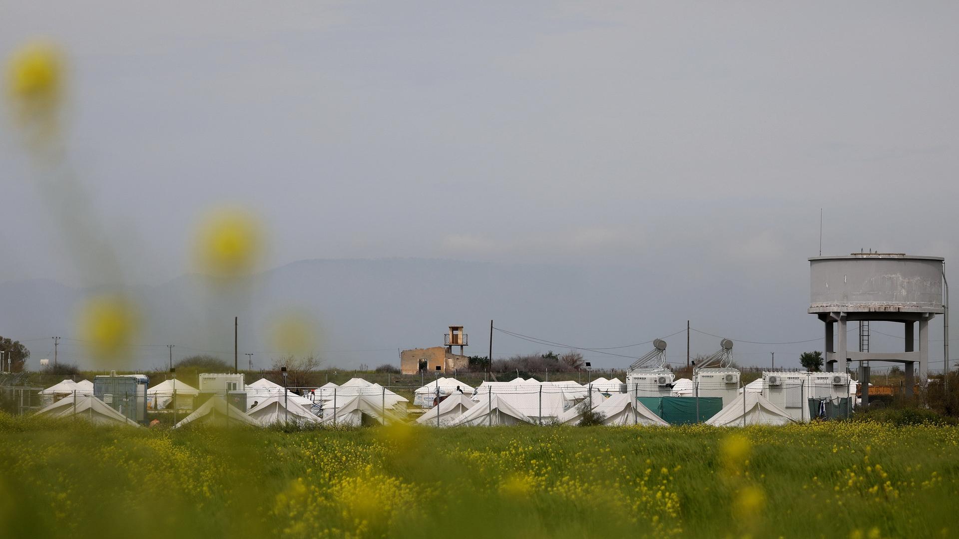 Ein Flüchtlingslager in Zypern: weiße Zelte hinter eine Zaun.