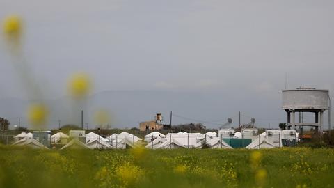 Ein Flüchtlingslager in Zypern: weiße Zelte hinter eine Zaun.
