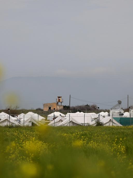 Ein Flüchtlingslager in Zypern: weiße Zelte hinter eine Zaun.