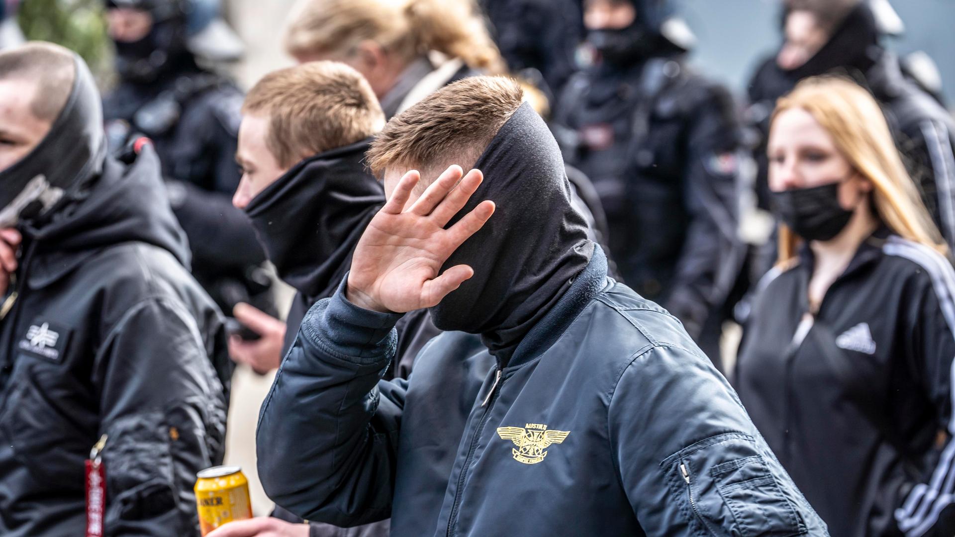 Die Neonazi-Gruppe "Jung und Stark" demonstriert in der Innenstadt von Essen. Ultra Rechte, in Schwarz gekleidet und mit szenetypischen Kleidungstücken. Ein Mann vorne verdeckt sein Gesicht. Die Neonazi-Gruppe "Jung und Stark" demonstriert in der Innenstadt von Essen. Ultra Rechte, in Schwarz gekleidet und mit szenetypischen Kleidungstücken. Ein Mann vorne verdeckt sein Gesicht.