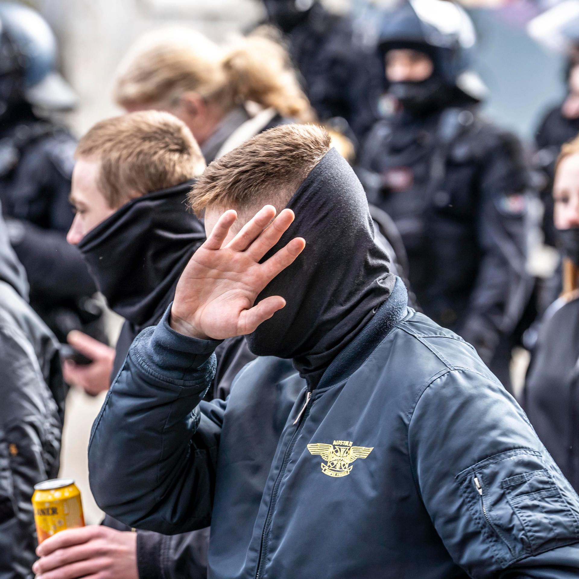 Die Neonazi-Gruppe "Jung und Stark" demonstriert in der Innenstadt von Essen. Ultra Rechte, in Schwarz gekleidet und mit szenetypischen Kleidungstücken. Ein Mann vorne verdeckt sein Gesicht.