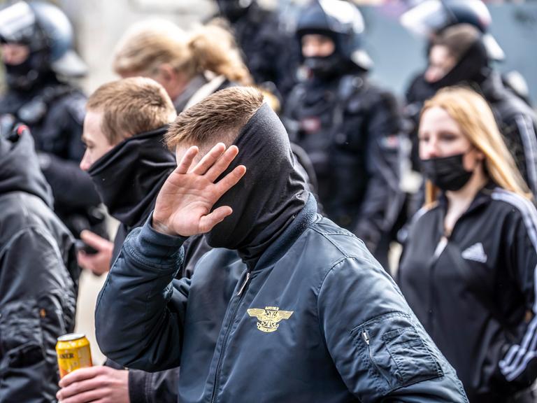 Die Neonazi-Gruppe "Jung und Stark" demonstriert in der Innenstadt von Essen. Ultra Rechte, in Schwarz gekleidet und mit szenetypischen Kleidungstücken. Ein Mann vorne verdeckt sein Gesicht.