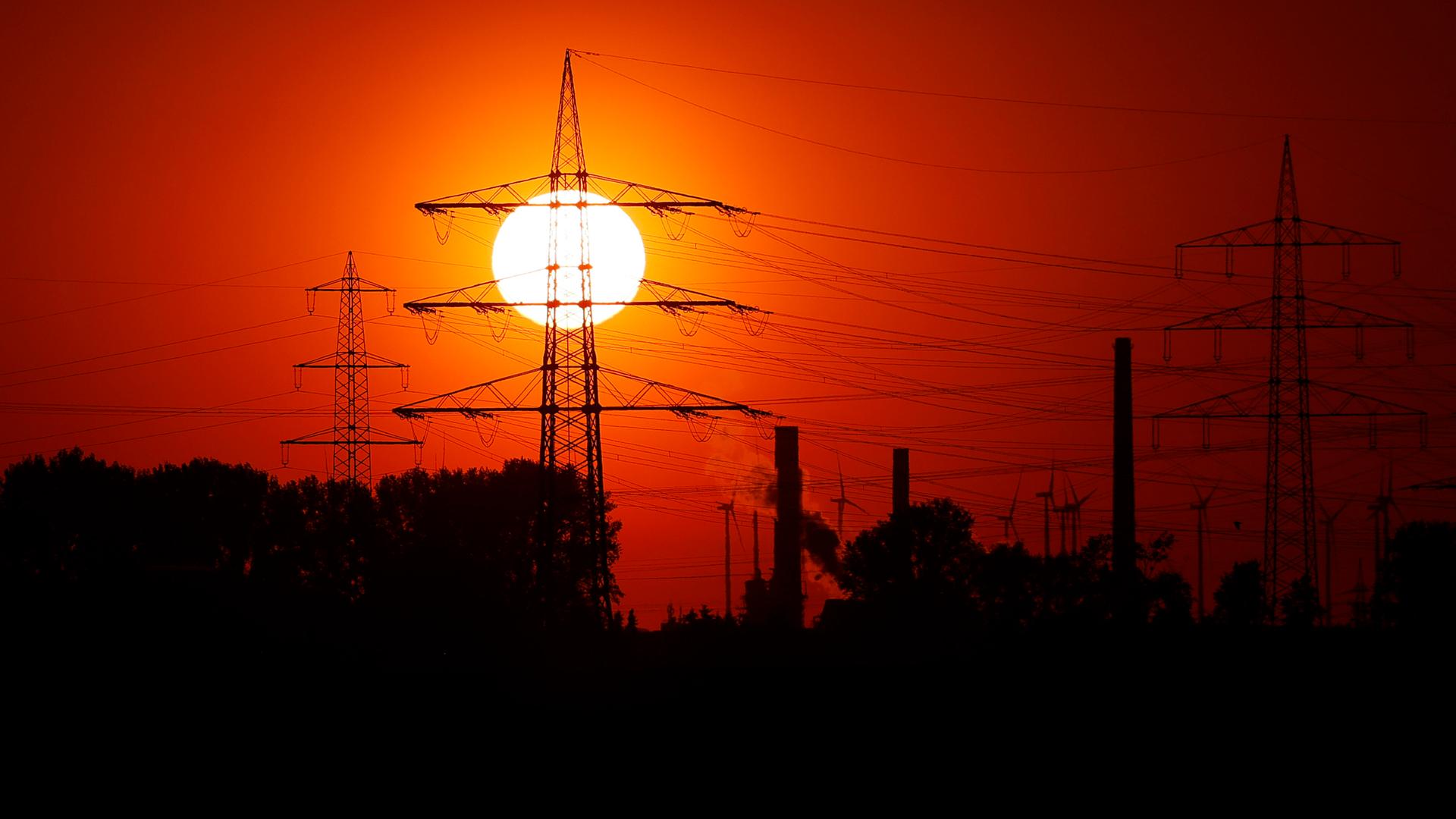Strommasten in der untergehenden Sonne zu sehen von einem Feld unweit des RWE-Kohlekraftwerk Niederaußem bei Bergheim. Strommasten in der untergehenden Sonne zu sehen von einem Feld unweit des RWE-Kohlekraftwerk Niederaußem bei Bergheim.