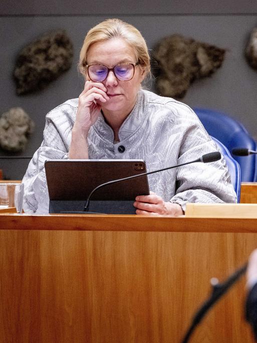 Sigrid Kaag sitzt mit einem Tablet in einer Plenarsitzung.