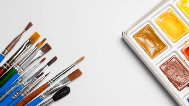 Eine Reihe von Aquarell-Farben und Pinsel auf einem weißen Hintergrund.