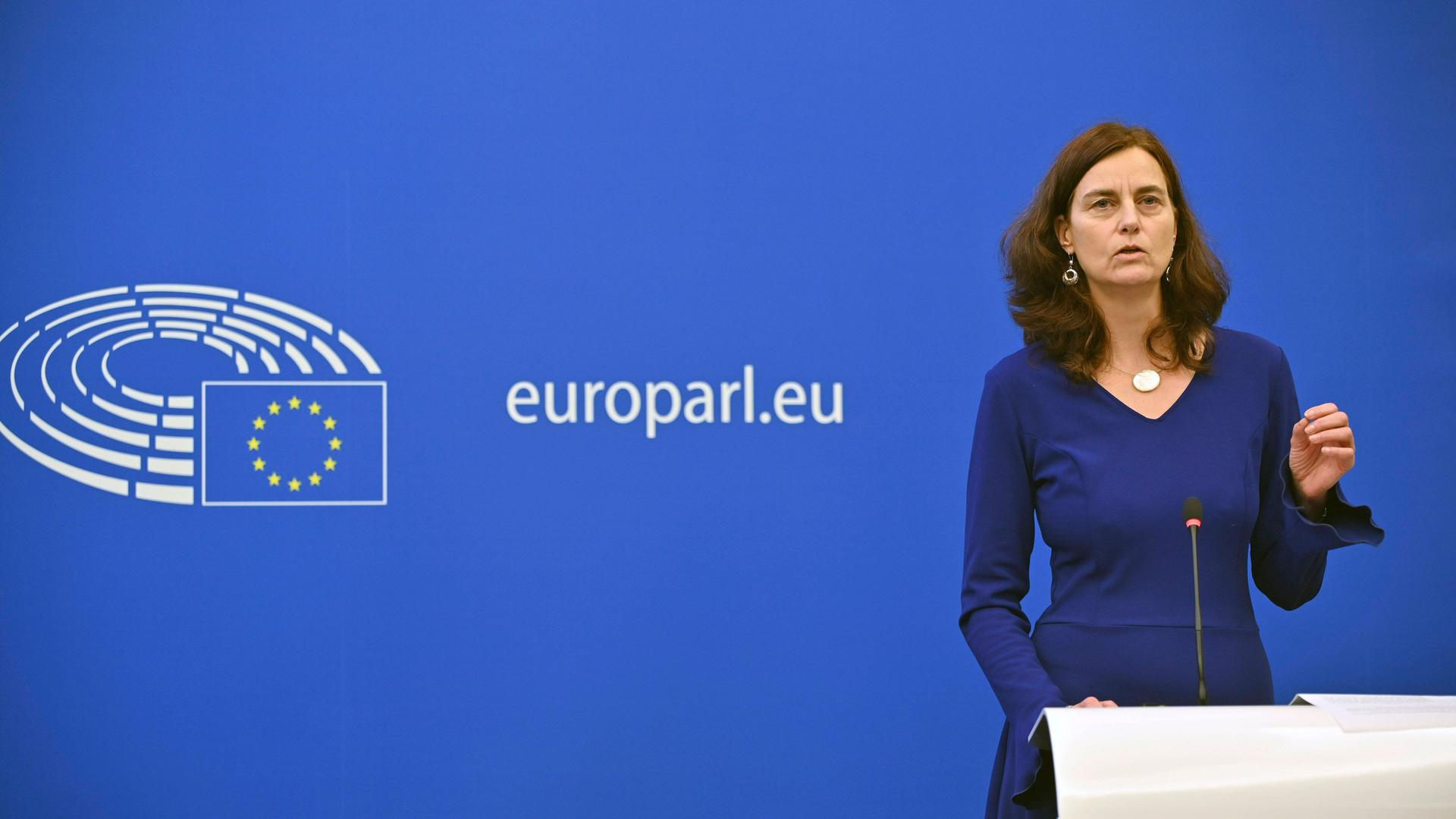 Die Europaabgeordnete Alexandra Geese steht während einer Pressekonferenz im Europäischen Parlament im blauen Kleid am Mikrofon.