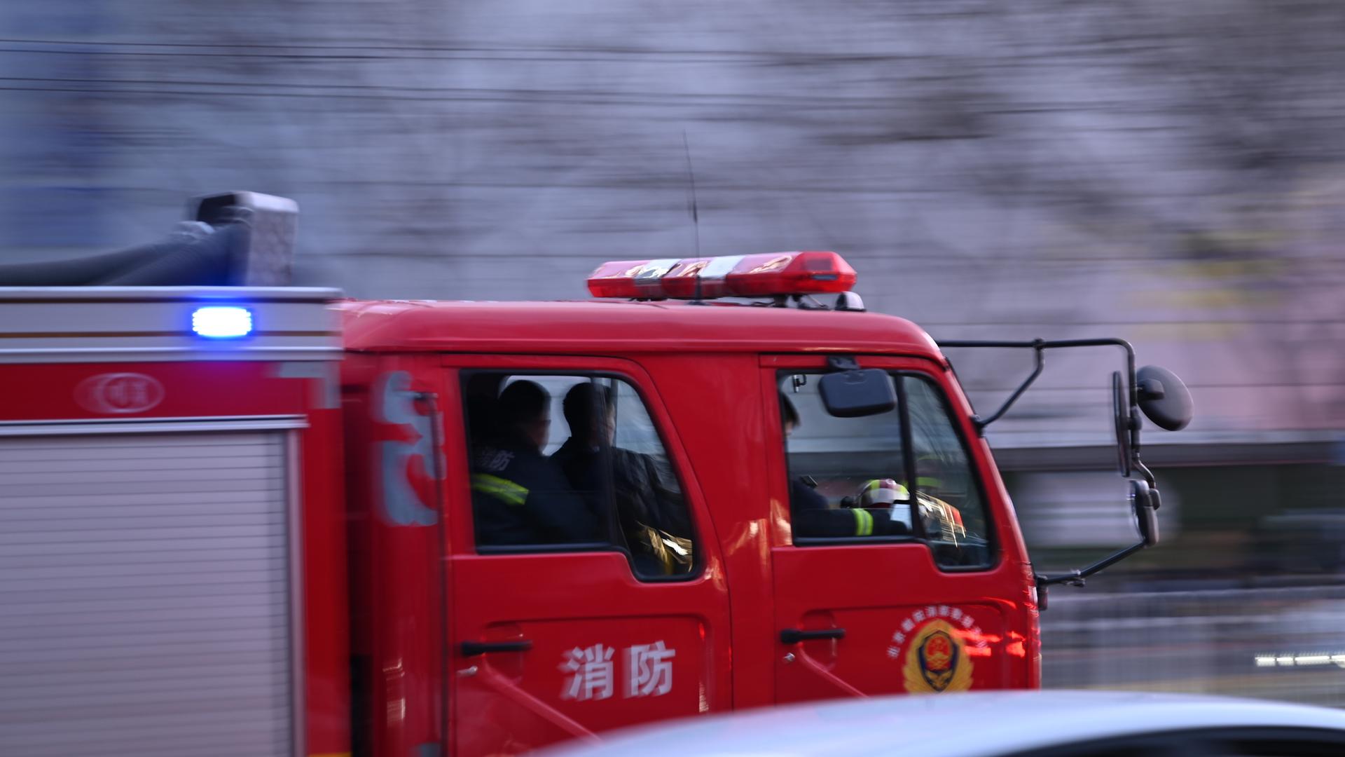 Ein chinesisches Feuerwehrauto fährt mit Blaulicht auf einer Straße. In der nordostchinesischen Stadt Liaoyang sind bei einem Restaurantbrand mindestens 22 Menschen gestorben. Ein chinesisches Feuerwehrauto fährt mit Blaulicht auf einer Straße. In der nordostchinesischen Stadt Liaoyang sind bei einem Restaurantbrand mindestens 22 Menschen gestorben.