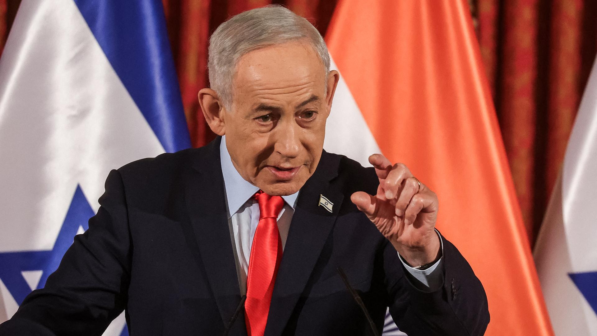 Israels Regierungschef Benjamin Netanjahu spricht bei einer Pressekonferenz anlässlich des Besuchs seines indischen Amtskollegen Narendra Modi in Jerusalem - er gestikuliert dabei. Im Hintergrund sieht man die Landesfahne Israels und Indiens.