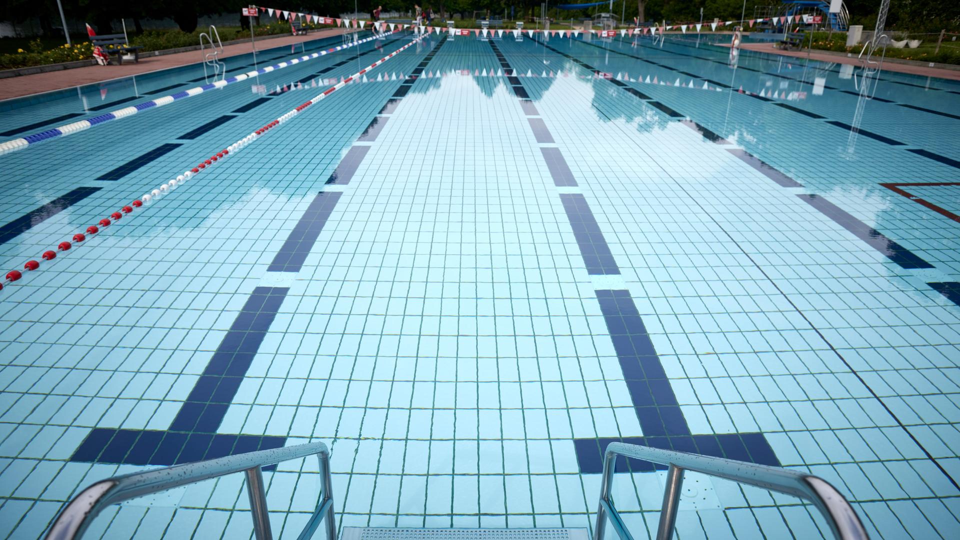 Blick in einen Außenpool eines Schwimmbades in Deutschland. Die verschiedenen Bahnen des Pools sind im Wasser gut zu erkennen.