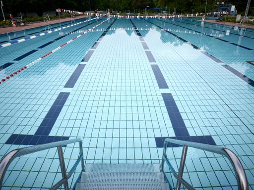 Blick in einen Außenpool eines Schwimmbades in Deutschland. Die verschiedenen Bahnen des Pools sind im Wasser gut zu erkennen.