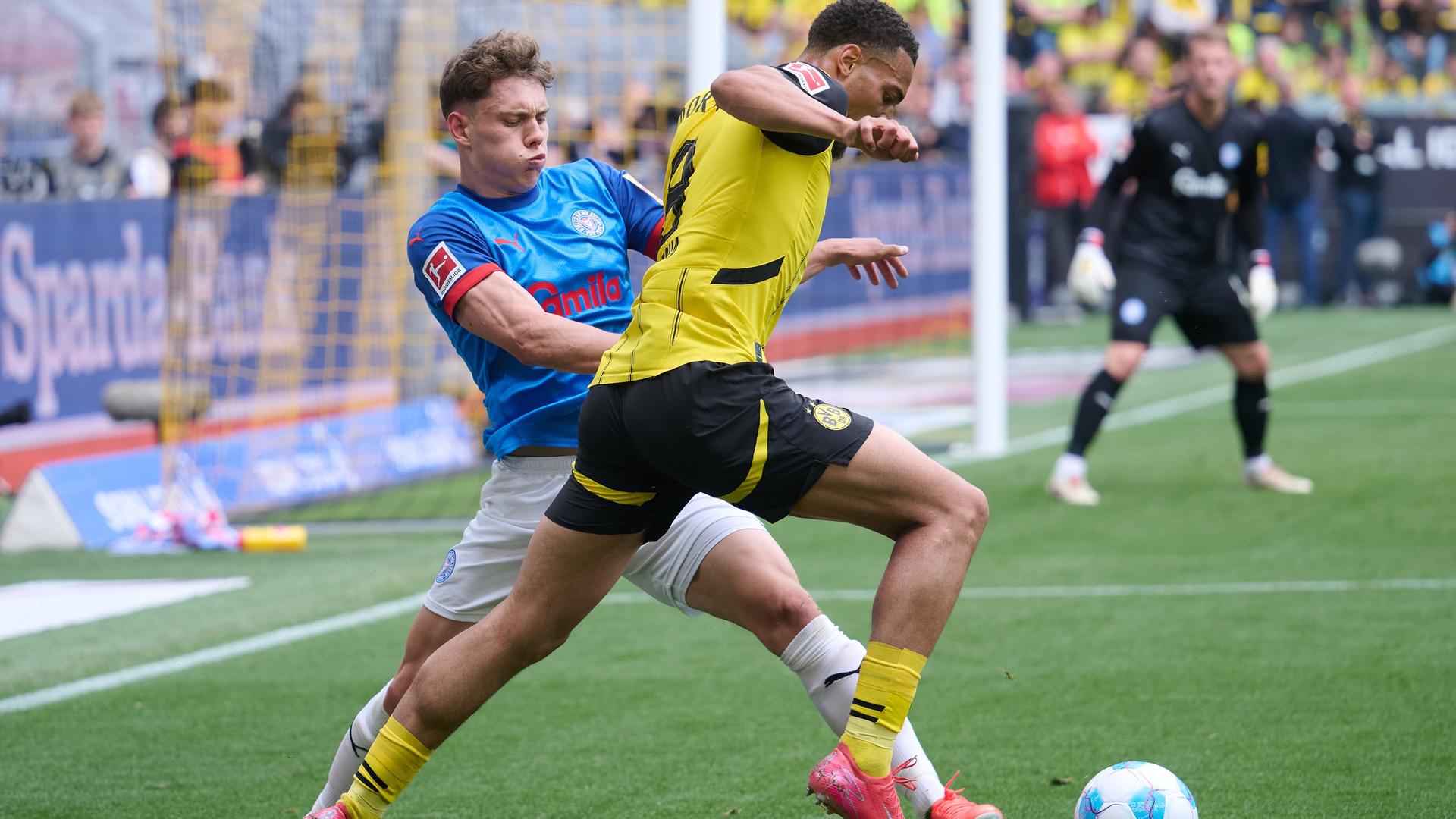 Fußball-Bundesliga: Borussia Dortmund - Holstein Kiel im Signal Iduna Park. Dortmunds Felix Nmecha und Nicolai Remberg von Kiel kämpfen um den Ball. 