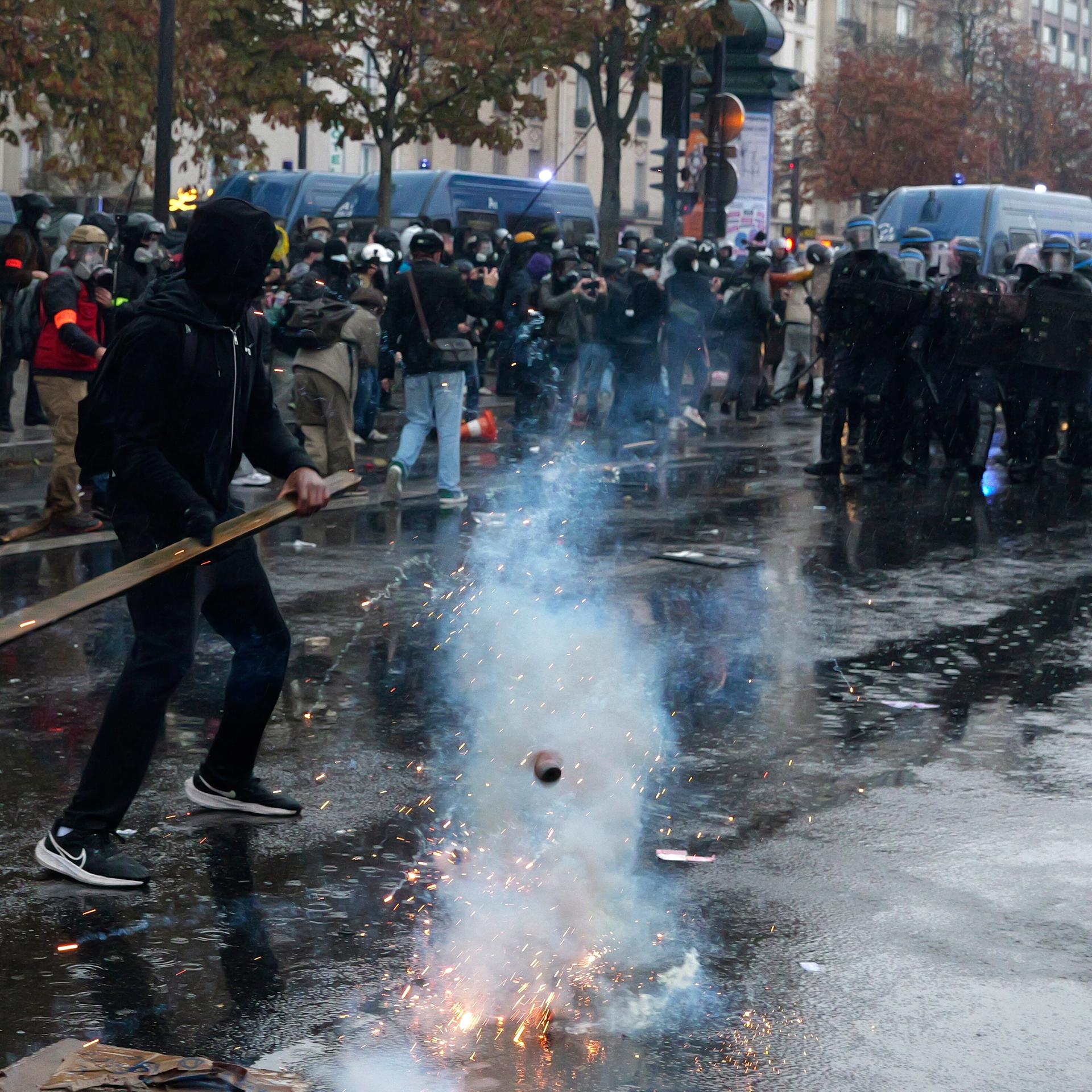 Ein Demonstrant steht mit einer Holzlatte in den Händen vor einer Polizeikette (Foto vom 24.10.2026). 