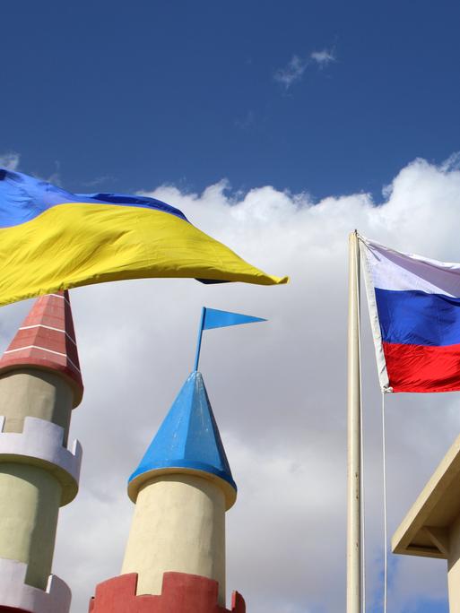 Bei einem Hotel in Sharm El Sheikh, Ägypten, wehen die Flaggen der Ukraine und Russlands vor hellblauem Himmel.