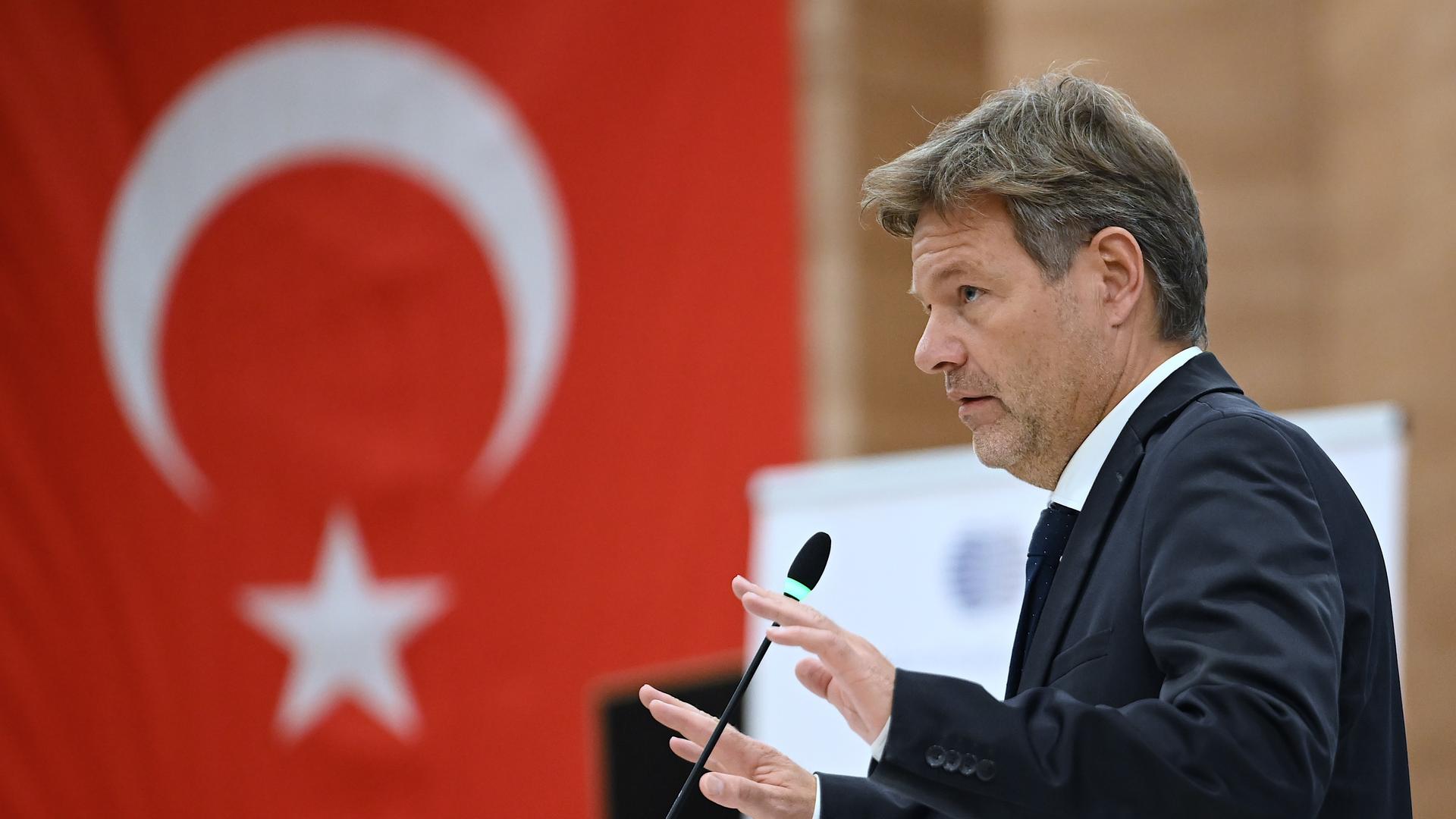 Wirtschaftsminister Robert Habeck spricht in der Türkei beim Deutsch-Türkischen Energieforum, im Hintergrund hängt eine türkische Flagge. 