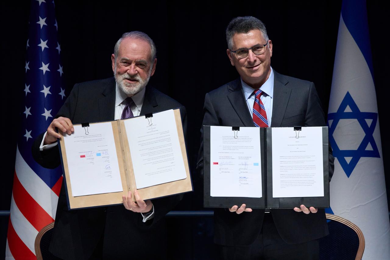 Zu sehen sind Mike Huckabee, US-Botschafter in Israel und Gideon Sa'ar (r.), Außenminister von Israel. Beide halten einen Vertrag in den Händen.