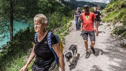 Eine Reihe von Wanderen auf einem Weg über einem See