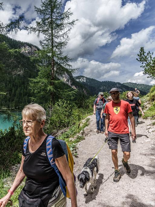 Eine Reihe von Wanderen auf einem Weg über einem See
