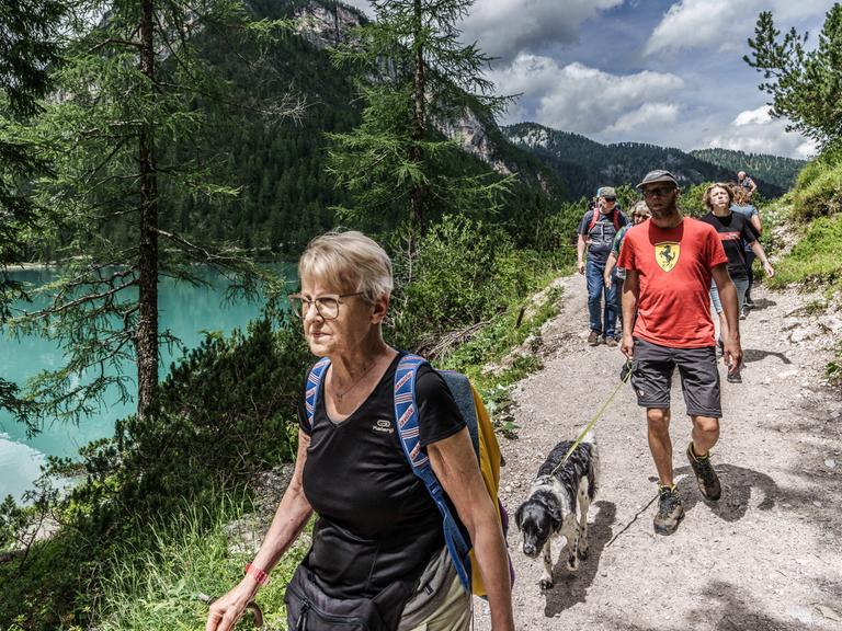 Eine Reihe von Wanderen auf einem Weg über einem See