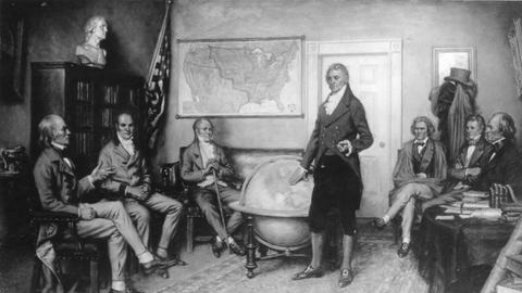 In dem Gemälde des Malers Clyde Deland sieht man eine Sitzung des US-amerikanischen Kabinetts im Jahr 1822. In der Mitte steht der damalige US-Präsident James Monroe. Die Diskussion über die Außenpolitik wird als Geburtsstunde der Monroe-Doktrin angesehen. 