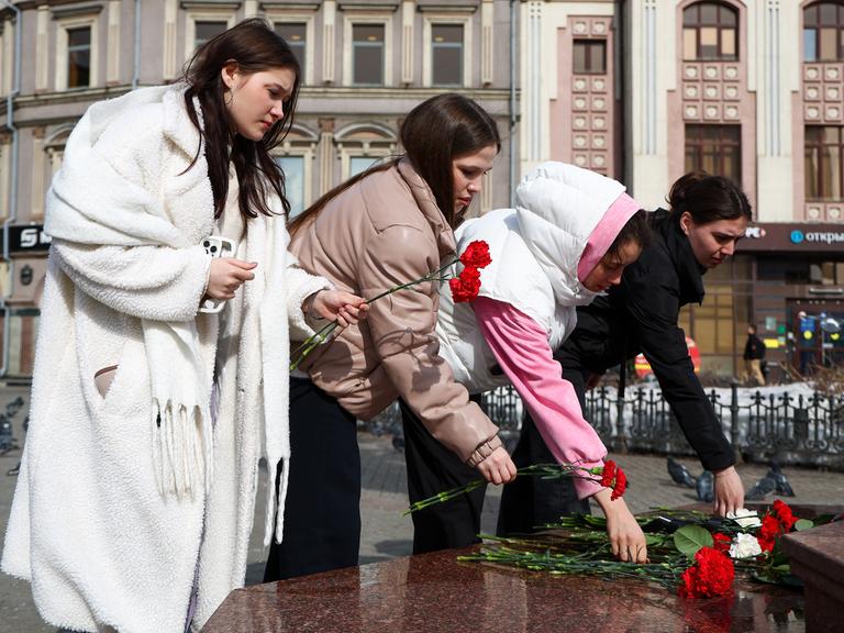 Junge Frauen legen in der tatarischen Hauptstadt Kasan Blumen nieder, um der um der Opfer des Anschlags in der Konzerthalle bei Moskau zu gedenken. 