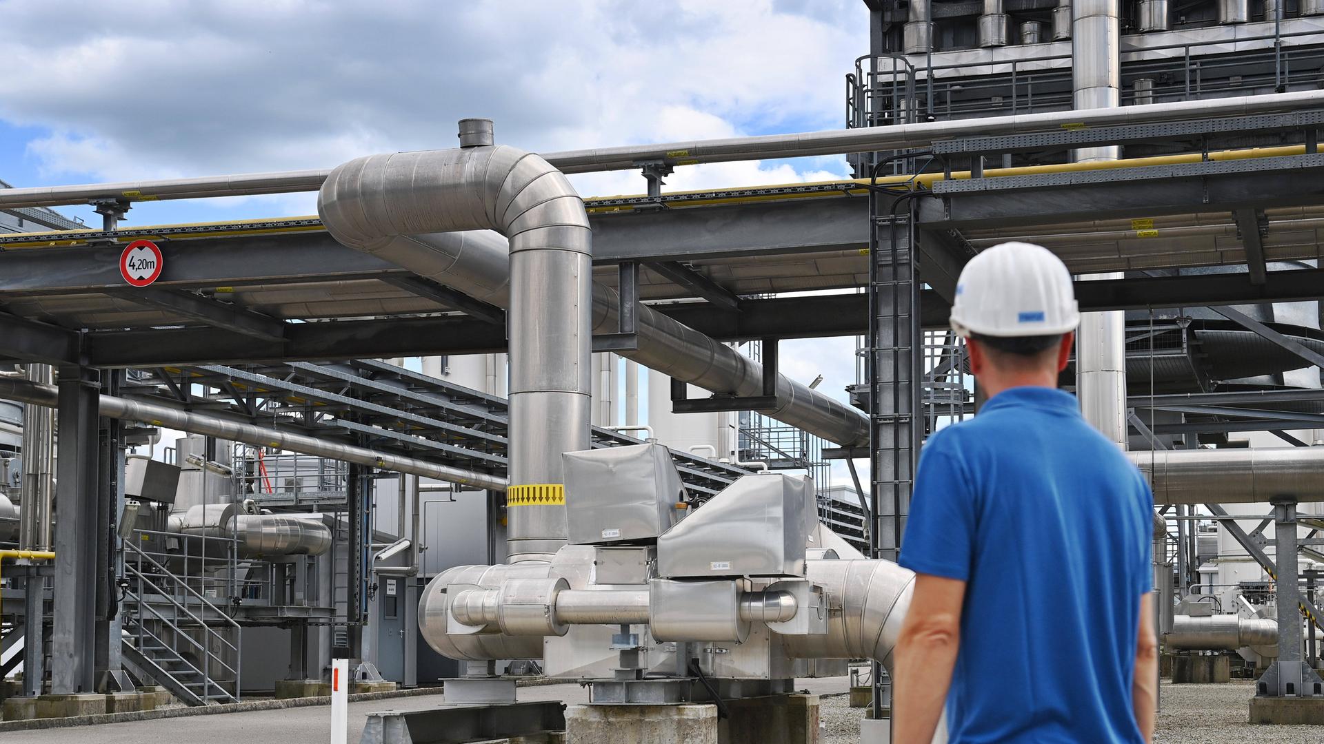 Gasspeicheranlage mit einem behelmten Arbeiter im Vordergrund