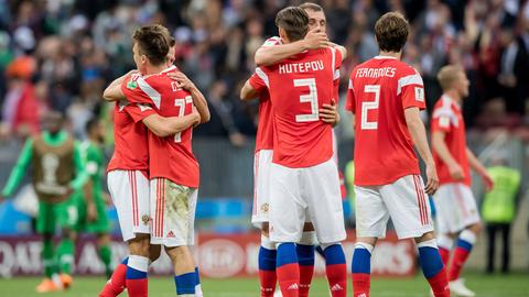 Spieler der russischen Nationalmannschaft im roten Trikots umarmen sich.