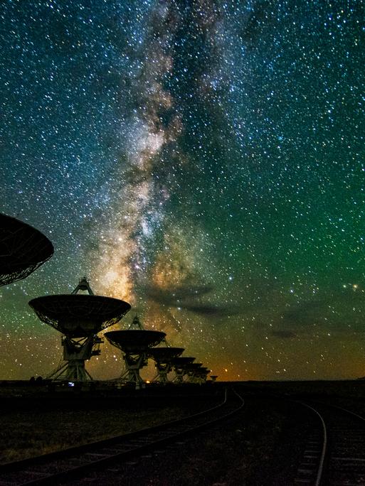 Eine Reihe von Teleskopen vor dem nächtlichen Sternenhimmel