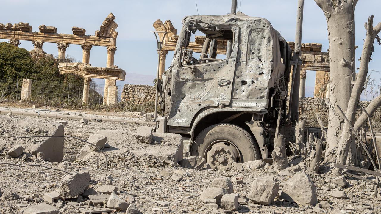 Ein ausgebrannter Lkw steht vor den Ruinen der antiken Tempelanlage Baalbek im Libanon.