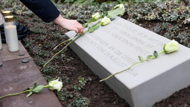 Weiße Rosen auf der Gedenk-Tafel für die Opfer von dem Terror-anschlag