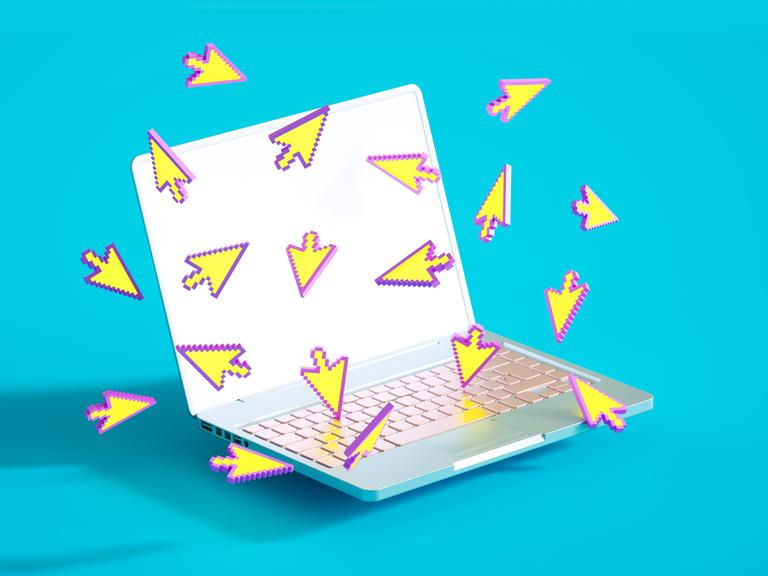 Viele digitale Curser Zeichen fliegen in unterschiedlichen Richtungen um einen aufgeklappten Laptop.