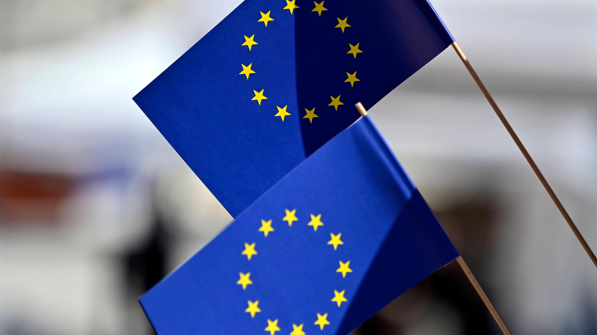 Zwei blaue EU-Flaggen mit dem Sternenkranz. Die Sterne stehen für die Länder in der Europäischen Union.