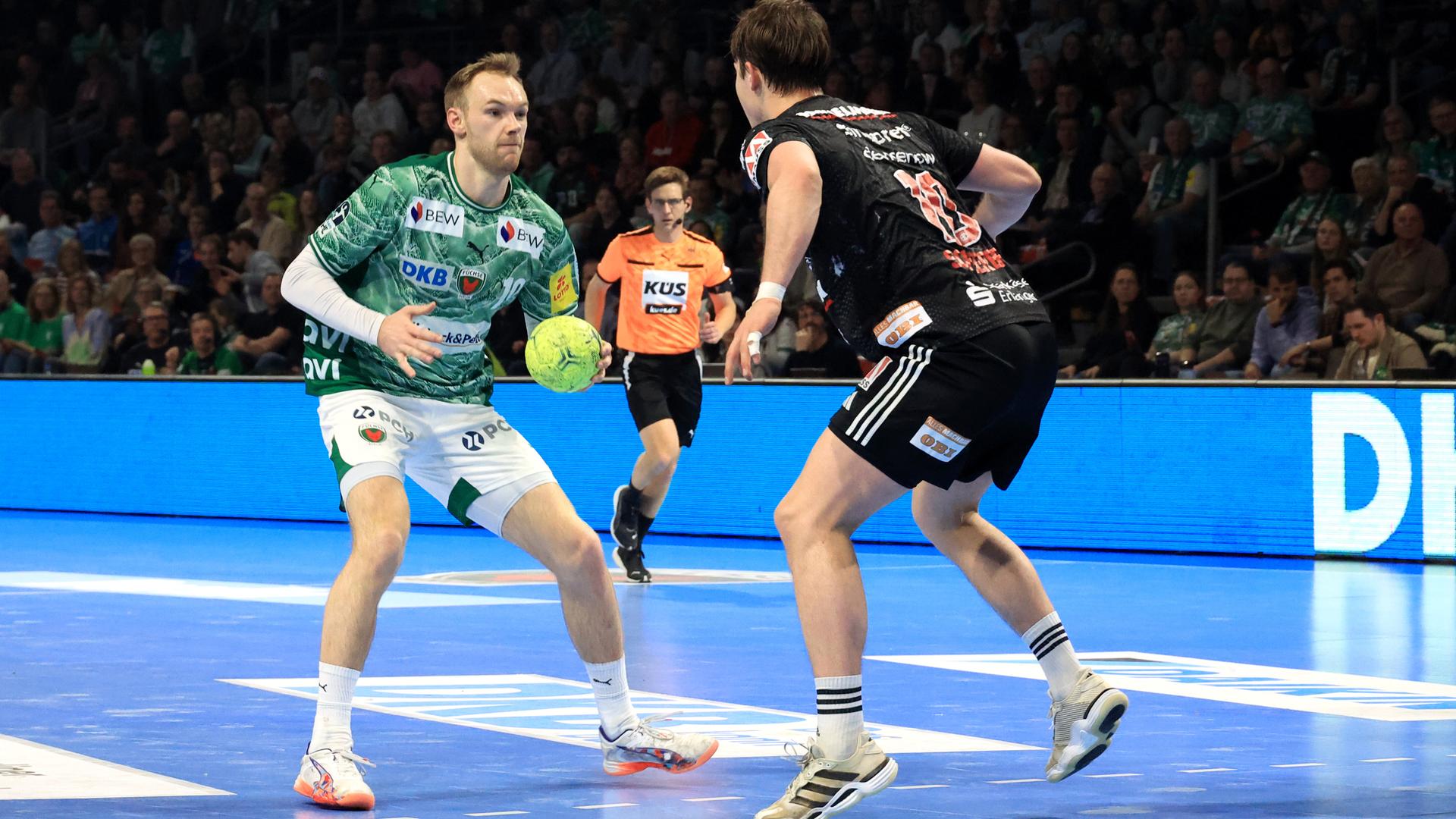Handballer Mathias Gidsel im Zweikampf mit einem Gegenspieler.