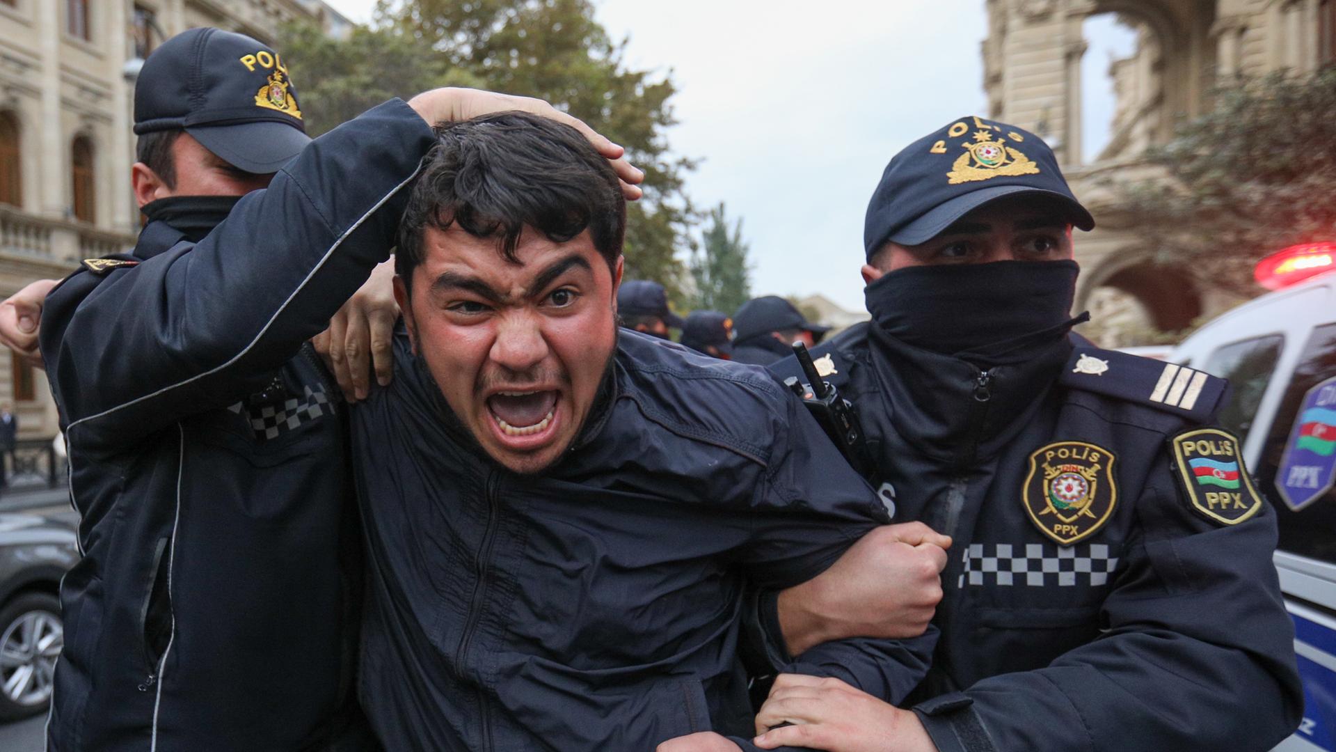 Polizeibeamte halten einen Demonstranten während einer Kundgebung der Partei Volksfront am 11. November 2022 in Baku fest. 