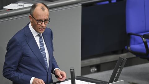 Bundeskanzler Merz steht am Rednerpult des Bundestags.