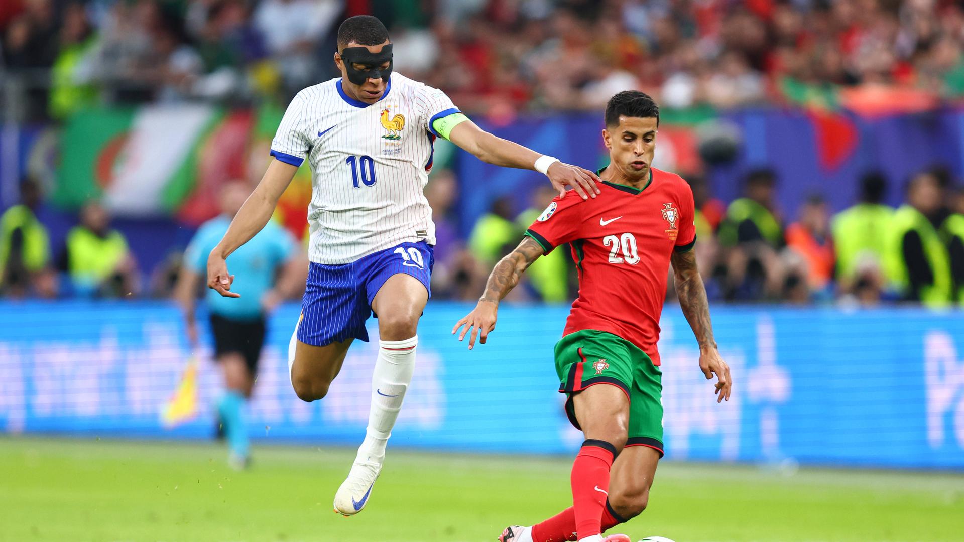 Kylian Mbappe für Frankreich (l.) und Joao Cancelo für Portugal kämpfen im Viertelfinalspiel in Hamburg um den Ball. Kylian Mbappe für Frankreich (l.) und Joao Cancelo für Portugal kämpfen im Viertelfinalspiel in Hamburg um den Ball.