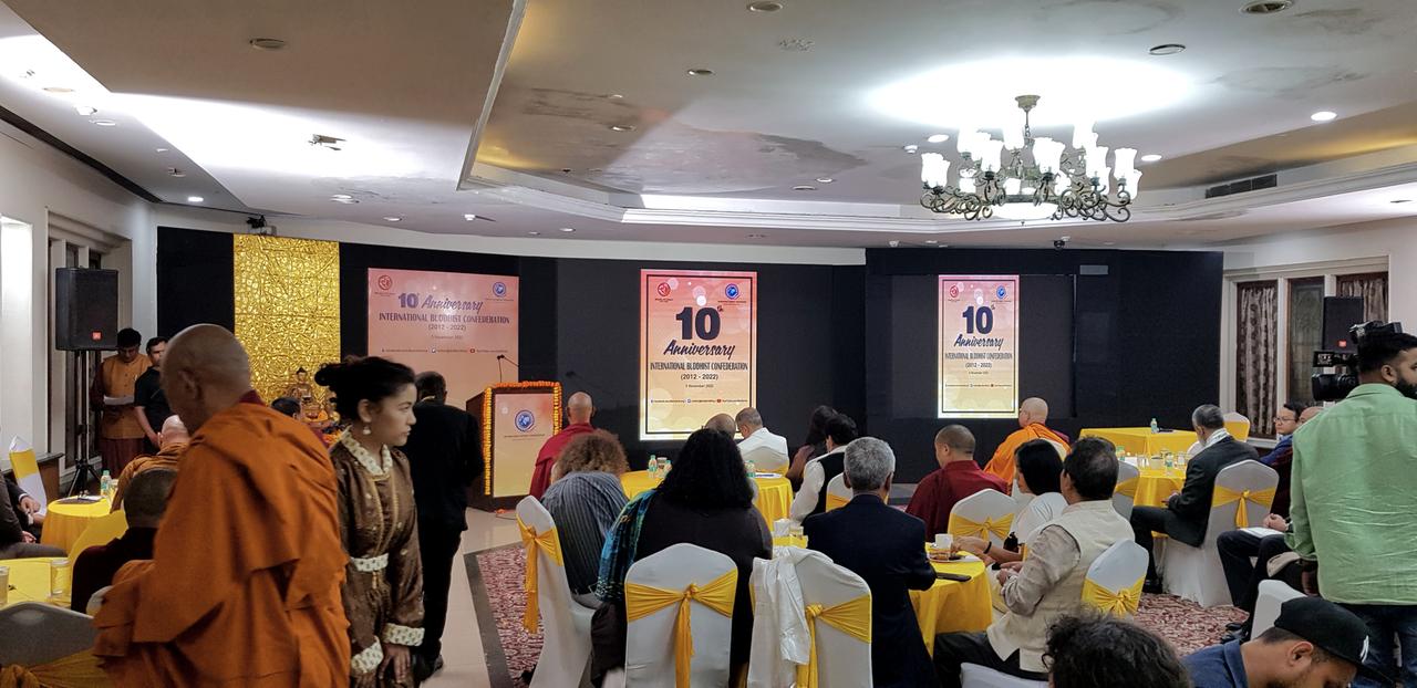 Menschen in einem geschmückten Raum feiern den zehnten Jahrestag der International Buddhist Confederation in Delhi.
