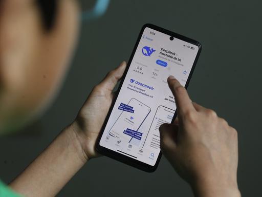 Eine Person hat die Downloadseite von DeepSeek auf einem Smartphone aufgerufen.