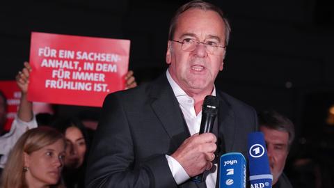 Bundesverteidigungsminister Pistorius spricht neben Demonstranten in ein Mikrofon.