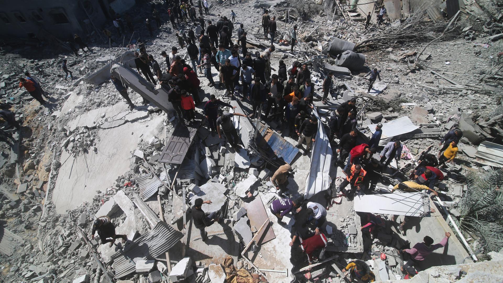 Palästinenser schauen sich ein zerstörtes Haus nach einem israelischen Angriff an.