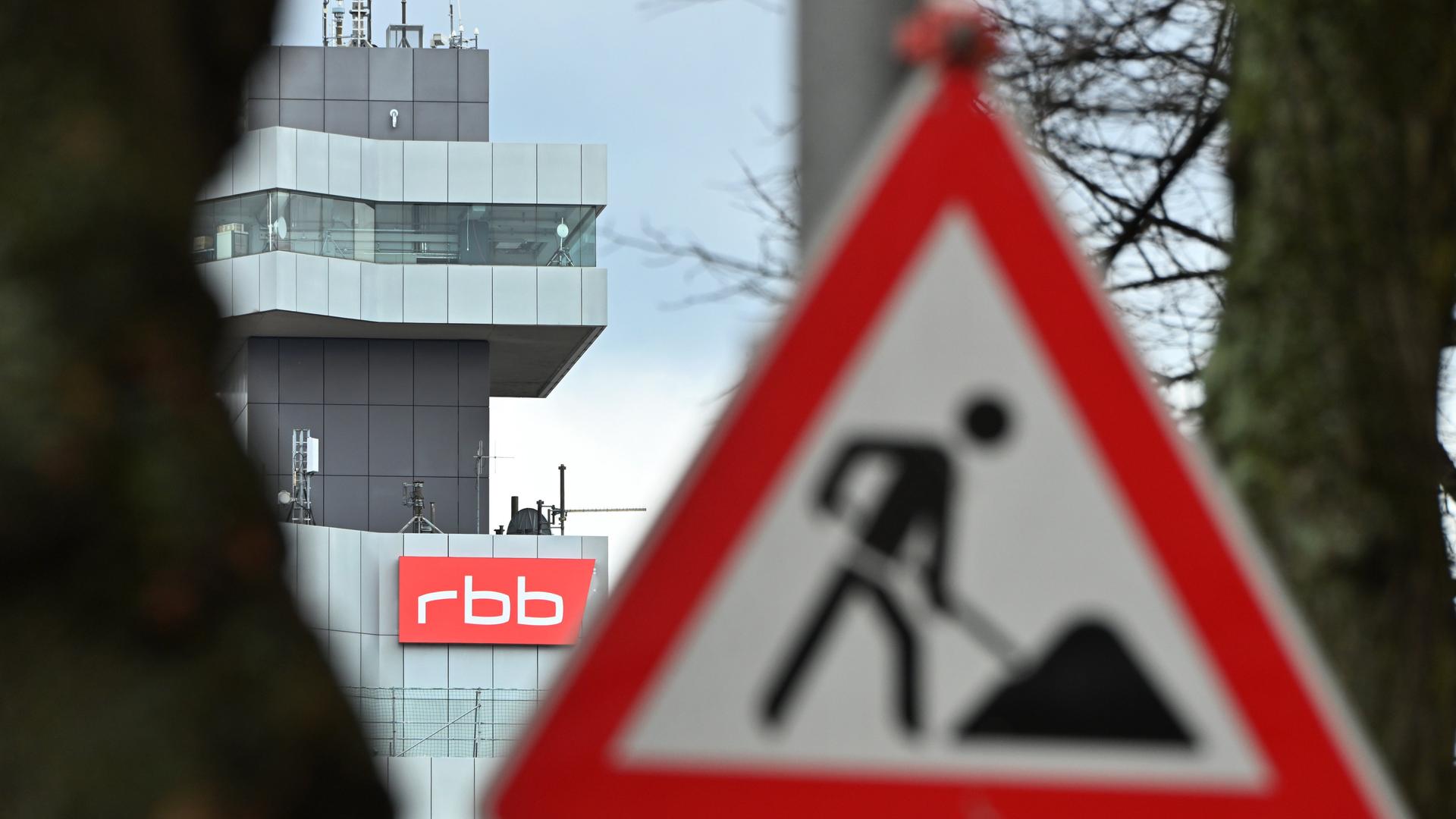 Ein Baustellenschild in Berlin weist auf eine Baustelle hin, im Hintergrund sieht man das Gebäude des RBB.