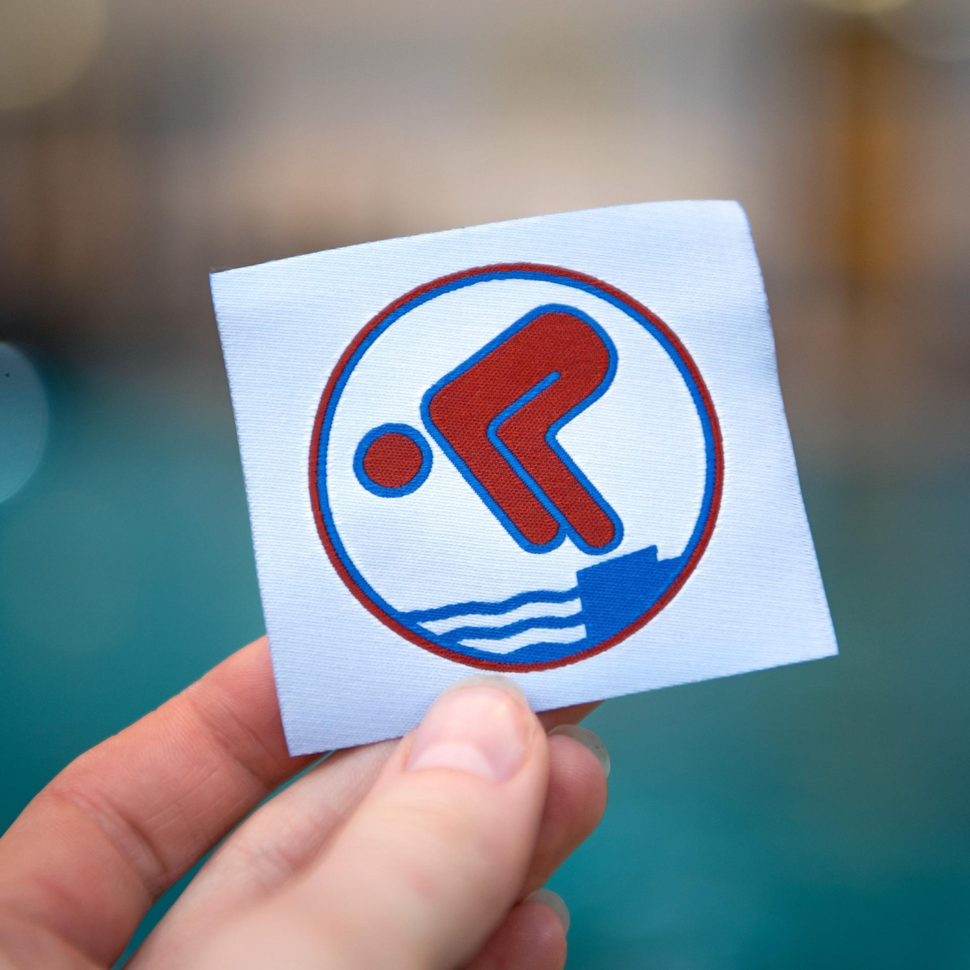 Ein Bronzeabzeichen wird am Beckenrand hochgehalten. 