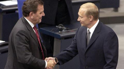 Zwei Mäner stehen in Anzügen im Reichstagsgebäude: Der russische Präsident Wladimir Putin (r.) wird am 25.9.2001 bei seinem Eintreffen zu einer Sondersitzung des Bundestages von Bundeskanzler Gerhard Schröder (SPD) begrüßt.