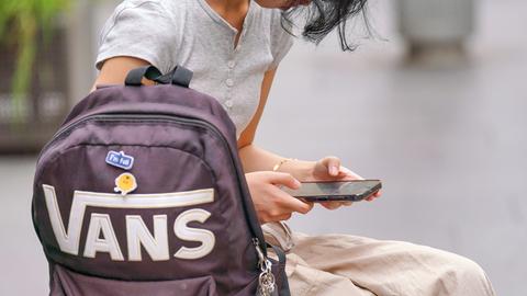 Ein junges Mädchen schaut auf ihr Handy Ein junges Mädchen schaut auf ihr Handy