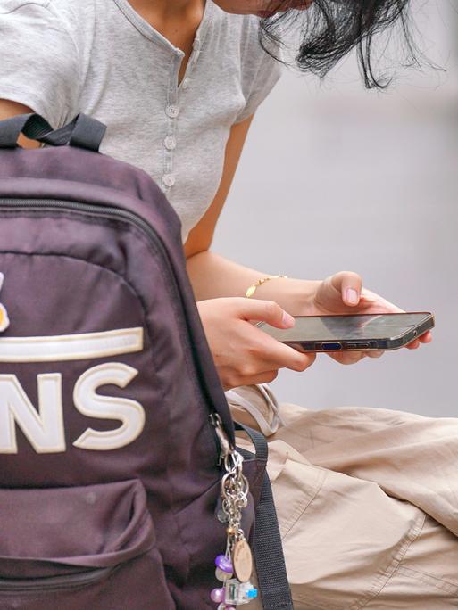 Ein junges Mädchen schaut auf ihr Handy