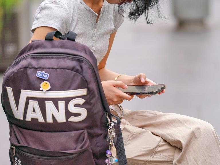 Ein junges Mädchen schaut auf ihr Handy