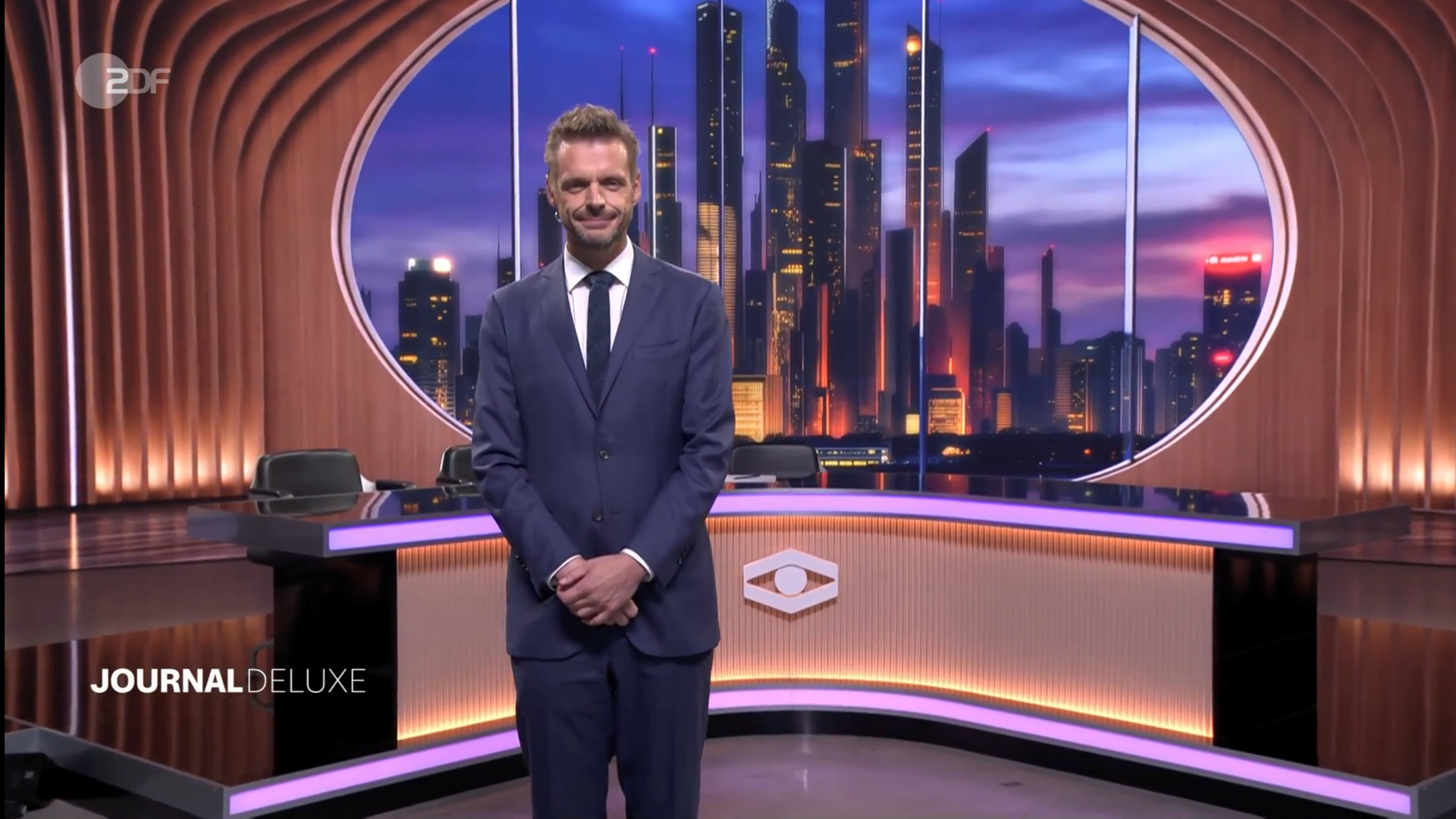 Moderator Florian Schroeder steht zu Beginn der ersten Ausgabe vom ZDF Journal Deluxe mit gefalteten Händen im Studio. Moderator Florian Schroeder steht zu Beginn der ersten Ausgabe vom ZDF Journal Deluxe mit gefalteten Händen im Studio.