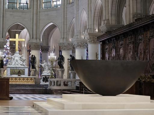 Blick in die renovierte Kathedrale Notre-Dame in Paris, im Vordergrund ist das neue Taufbecken aus Bronze zu sehen.