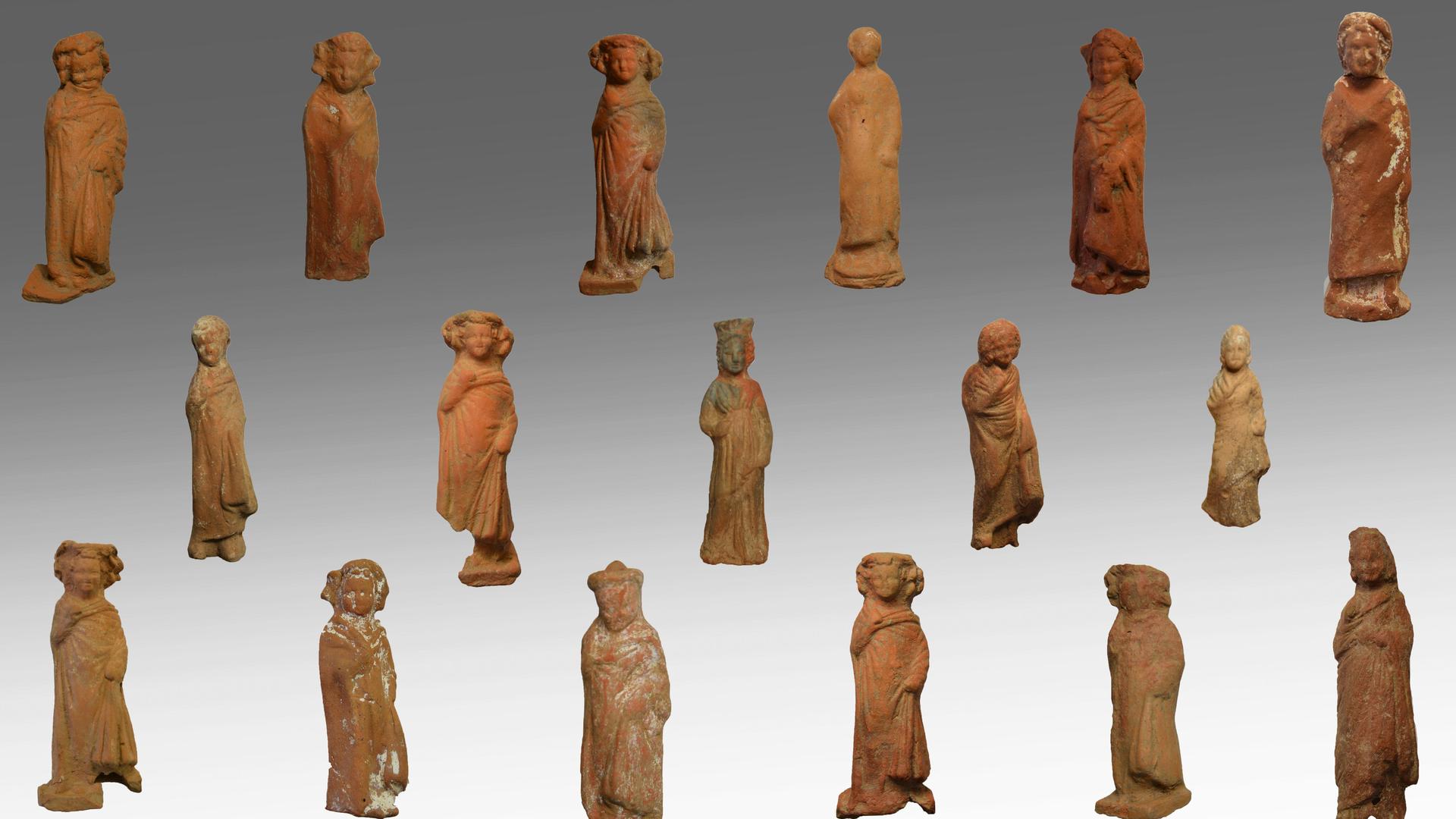 Man sieht viele Figuren aus Lehm, die Jungen und Mädchen darstellen. Man sieht viele Figuren aus Lehm, die Jungen und Mädchen darstellen.