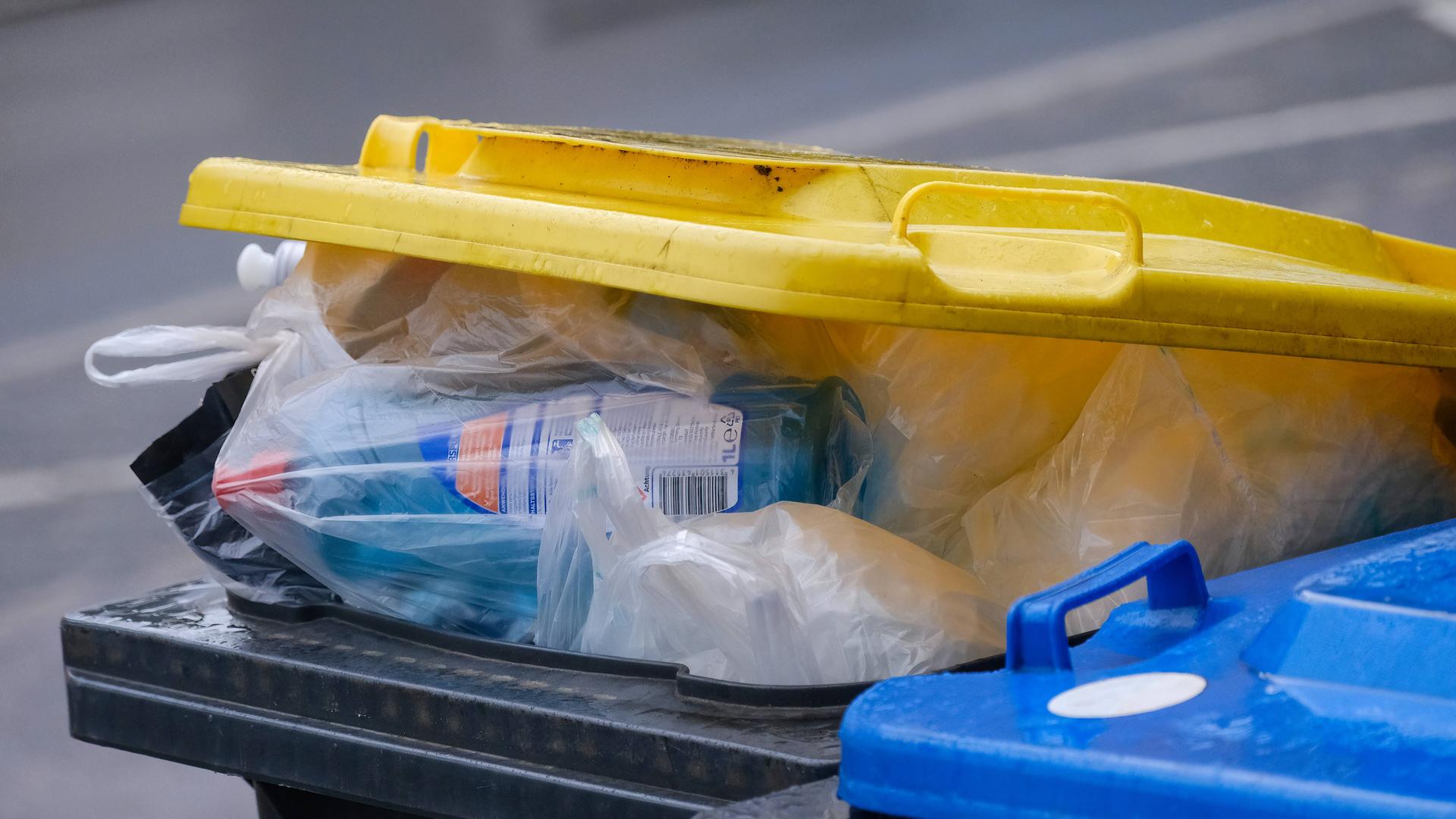 Eine überquellende "gelbe Tonne" mit Plastikmüll. 
