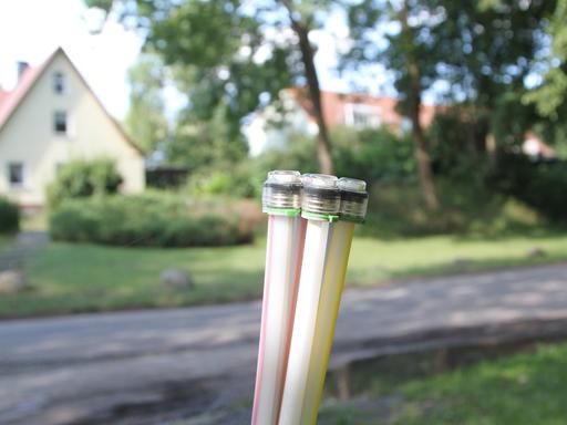 Zu sehen sind Zuleitungen für den Breitbandausbau in Röbel im Landkreis Mecklenburgische Seenplatte In Mecklenburg Vorpommern. Im Hintergrund ist der Unschärfe ein Haus und eine Straße zu erkennen.